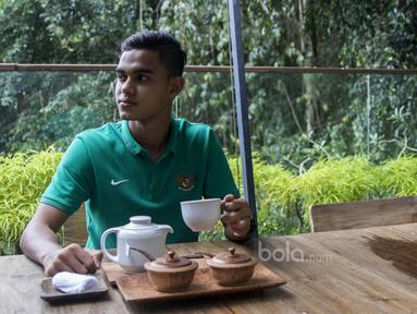 Gelandang Timnas Indonesia U-22, Miftahul Hamdi, mengisi waktu luang dengan menikmati secangkir teh di Hotel Sthala, Bali, Sabtu (8/7/2017). Pemain Bali United ini sedang mengikuti pemusatan latihan jelang SEA Games. (Bola.com/Vitalis Yogi Trisna)