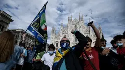 Para pendukung dan fans Inter Milan mengibarkan bendera dan meneriakkan yel-yel di kawasan Piazza Duomo, Milan, Minggu (2/5/2021) merayakan kepastian Inter Milan merebut gelar juara Scudetto Liga Italia 2020/2021. (AFP/Piero Cruciati)