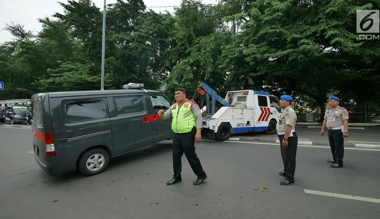 Petugas Ditlantas Polda Metro Jaya membawa mobil dinas polisi di Mapolsek Ciracas, Jakarta, Rabu (12/12). Polsek Ciracas dirusak oleh sekelompok orang tak dikenal dini hari tadi. (Liputan6.com/Herman Zakharia)