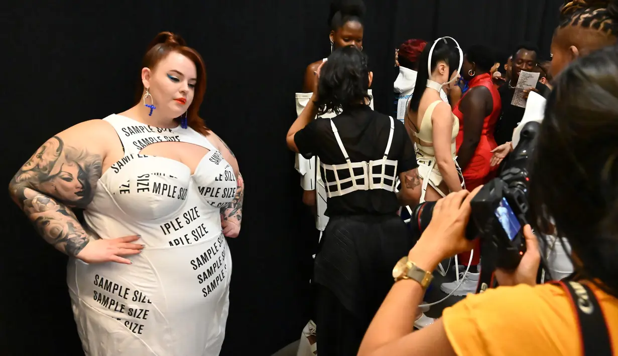 Tess Holliday, model dan aktivis bertubuh gemuk, bersiap di belakang panggung untuk show Chromat selama New York Fashion Week 2019 pada 7 September 2019. Model berbobot tubuh 137 kg tersebut tampil percaya diri mengenakan gaun panjang putih. (Astrid Stawiarz/Getty Images for TRESemme/AFP)