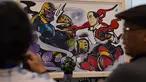 Pengunjung melihat  gambar komik yang menunjukkan Presiden Indonesia Joko Widodo, sebagai karakter Avenger versus Thanos di Festival Pop Culture Popcon Asia 2018 di BSD, Tangerang Selatan, Sabtu (22/9). (AFP PHOTO / BAY ISMOYO)