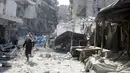 Warga mencari korban yang tertimbun di reruntuhan akibat serangan udara di distrik al-Fardous, Aleppo, Suriah, Rabu (12/10). Serangan udara terhadap kota yang dikuasai oleh pemberontak di Aleppo menewaskan sedikitnya 15 orang. (REUTERS/Abdalrhman Ismail)