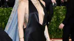 Penyanyi dan artis Hollywood, Miley Cyrus berpose setibanya menghadiri ajang Met Gala 2018 di Metropolitan Museum of Art New York, Senin (7/5). Bagian depan gaun rancangan dari Stella McCartney itu pun tak kalah terbuka. (Evan Agostini/Invision/AP)