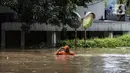 Petugas berjalan menyusuri banjir di kawasan Kemang, Jakarta, Sabtu (20/2/2021). Curah hujan yang tinggi menyebabkan kawasan tersebut terendam banjir setinggi orang dewasa. (Liputan6.com/Johan Tallo)