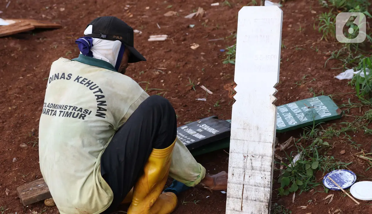 Petugas menyiapkan papan nisan jenazah yang akan dimakamkan dengan protokol COVID-19 di TPU Pondok Ranggon, Jakarta, Kamis (12/10/2020). Gubernur DKI Jakarta Anies Baswedan menganggarkan Rp254 miliar guna menambah lahan pemakaman jenazah dengan protokol Covid-19. (Liputan6.com/Helmi Fithriansyah)