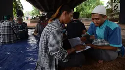 Anak punk saat belajar mengaji dengan Iqro bersama Komunitas Tasawuf Underground di kolong flyover Tebet, Jakarta, Sabtu (8/12). Komunitas ini mengajak anak-anak punk dan anak jalanan kembali ke kehidupan yang baik. (Merdeka.com/Imam Buhori)