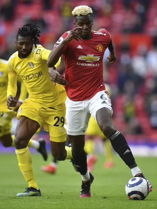 Gelandang Manchester United (MU), Paul Pogba berebut bola dengan gelandang Fulham, Andre-Frank Zambo Anguissa pada pekan 37 Liga Inggris di Stadion Old Trafford, Rabu (19/5/2021) dinihari WIB. MU kembali gagal menang setelah ditahan imbang 1-1 oleh tamunya Fulham. (AP Photo/Paul Ellis, Pool)