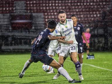 Pemain Persib Bandung, Marc Klok (kanan), berusaha melewati hadangan pemain Arema FC, Jayus Hariono (kiri) dalam pertandingan pekan kedua BRI Liga 1 2023/2024 yang berlangsung di Stadion Kapten I Wayan Dipta, Bali, Jumat (7/7/2023). (Bola.com/Alit Binawan)