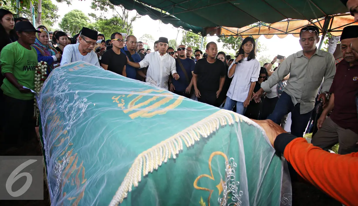 Presenter Farhan bersama keluarga mengikuti proses pemakaman anak pertamanya Muhammad Ridzky Khalid di TPU Tanah Kusir, Jakarta, Senin (21/12). Ridzky menghebuskan nafas terakhirnya akibat penyakit leukimia. (Liputan6.com/Immanuel Antonius)