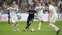 Penyerang Prancis, Kylian Mbappe, berusaha melewati pemain Jerman pada laga UEFA Nations League di Stade de France, Paris, Selasa (16/10/2018). Prancis menang 2-1 atas Jerman. (AP/Christophe Ena)
