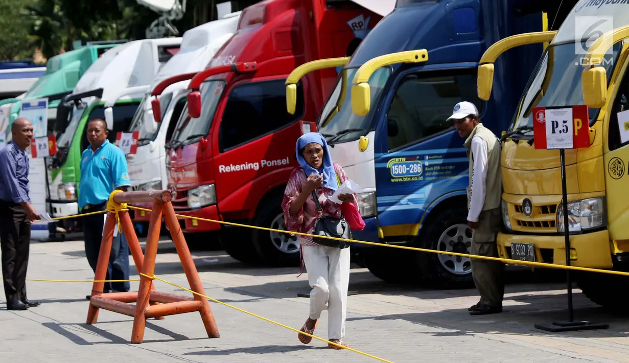 Warga berjalan menuju mobil kas keliling penukaran uang pecahan di Lapangan IRTI Monas, Jakarta, Rabu (7/6). Bank Indonesia bersama 13 bank umum melayani kebutuhan masyarakat akan uang pecahan selama Ramadan dan Idul Fitri 2017 (Liputan6.com/Angga Yuniar)