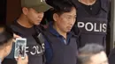 Anggota polisi mengawal WN Korea Utara, Ri Jong Chol (tengah) menuju kantor imigrasi Malaysia, di markas Polisi Sepang, Jumat (3/3). Ri Jong Chol, tersangka pembunuh Kim Jong-nam, akan dideportasi tanpa tuduhan apapun. (Muneyoshi Someya/Kyodo News via AP)