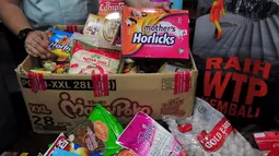 Salah satu petugas menunjukkan kemasan produk pangan Tanpa Izin Edar (TIE) di Jakarta, (22/12/2014). Jelang Natal 2014 dan Tahun Baru 2015 BPOM menemukan 2.939 item atau 72.814 kemasan pangan Tidak Memenuhi Ketentuan (TMK). (Liputan6.com/Johan Tallo)