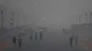 Pejalan kaki berjalan di tengah-tengah kondisi kabut asap tebal di New Delhi (2/11). Tingkat kabut melonjak selama musim dingin di Delhi, ketika kualitas udara melampaui tingkat aman Organisasi Kesehatan Dunia. (AP Photo/Money Sharma)