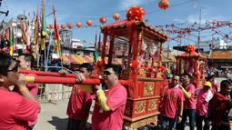 Warga keturunan Thailand-China mengarak kereta kayu yang membawa patung Dewi yang sangat dihormati dari Kuil Chao Mae To Mo saat merayakan festival keagamaan tahunan di distrik Sungai Kolok, Thailand (8/5). (AFP/Madaree Tohlala)