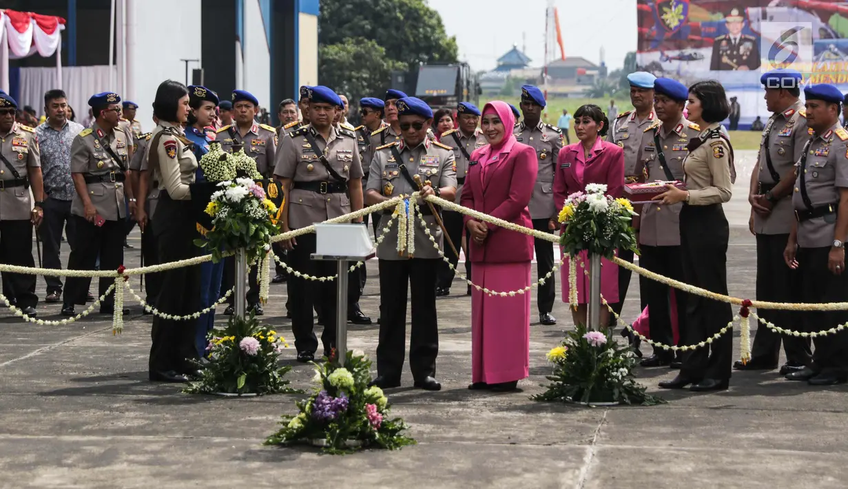 Kapolri Jenderal Tito Karnavian didampingi Istri Tri Suswati mengunting pita saat menyerahkan dua helikopter jenis Bell 429 IGW dari PT Multi Pasific California usai menghadiri  HUT Korpolairud ke-67, Tangerang, Selasa (5/11). (Liputan6.com/Faizal Fanani)