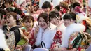 Sejumlah gadis Jepang mengenakan kimono saat menghadiri upacara Coming of Age Day atau Hari Kedewasaan di Tokyo Disneyland, di Urayasu, Senin (13/1/2020). Hari Kedewasaan adalah hari libur umum Jepang yang diadakan setiap hari Senin, minggu kedua di bulan Januari tiap tahunnya. (Kazuhiro NOGI/AFP)
