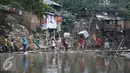 Sejumlah warga membawa barang miliknya menyeberangi kali Ciliwung usai penggusuran di Kampung pulo, Jakarta, Jumat (21/8/2015). Penggusuran terkait rencana Pemprov DKI Jakarta yang akan melakukan normalisasi Kali Ciliwung. (Liputan6.com/Gempur Surya)