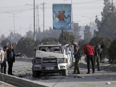 Petugas keamanan memeriksa lokasi serangan bom di Kabul, Afghanistan, Selasa (2/2/2021).  Sebuah bom pinggir jalan meledak Selasa di ibu kota Kabul, menewaskan dua orang dan melukai beberapa orang.  (AP Photo/Rahmat Gul)