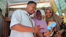 Ragaia Sosir melayani konsumen menggunakan mesin EDC BRI di kiosnya di Kampung Arar. Melalui layanan BRILink Agen, warga dapat melakukan berbagai transaksi tanpa harus bepergian jauh ke luar kampung. (Sumber: BRI/Advertorial)