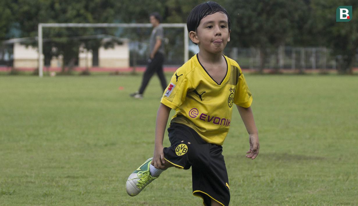 Anak dari Stefano Teco, yang bernama Romario, bermain saat latihan Persija Jakarta di Lapangan Sutasoma, Jakarta, Minggu (25/2/2018). Ketika ayahnya bekerja sang anak asyik bermain sepak bola. (Bola.com/Aspirilla Dwi Adha)