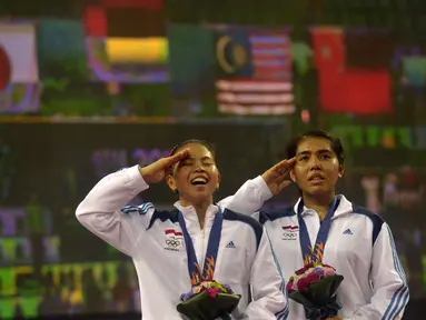 Nitya Krishinda (kanan) dan Gresya Polii menyanyi Indonesia Raya ketika pengibaran bendera merah putih di Gyeyang Gymnasium, Incheon, Korsel, (27/9). (ANTARA FOTO/SAPTONO)