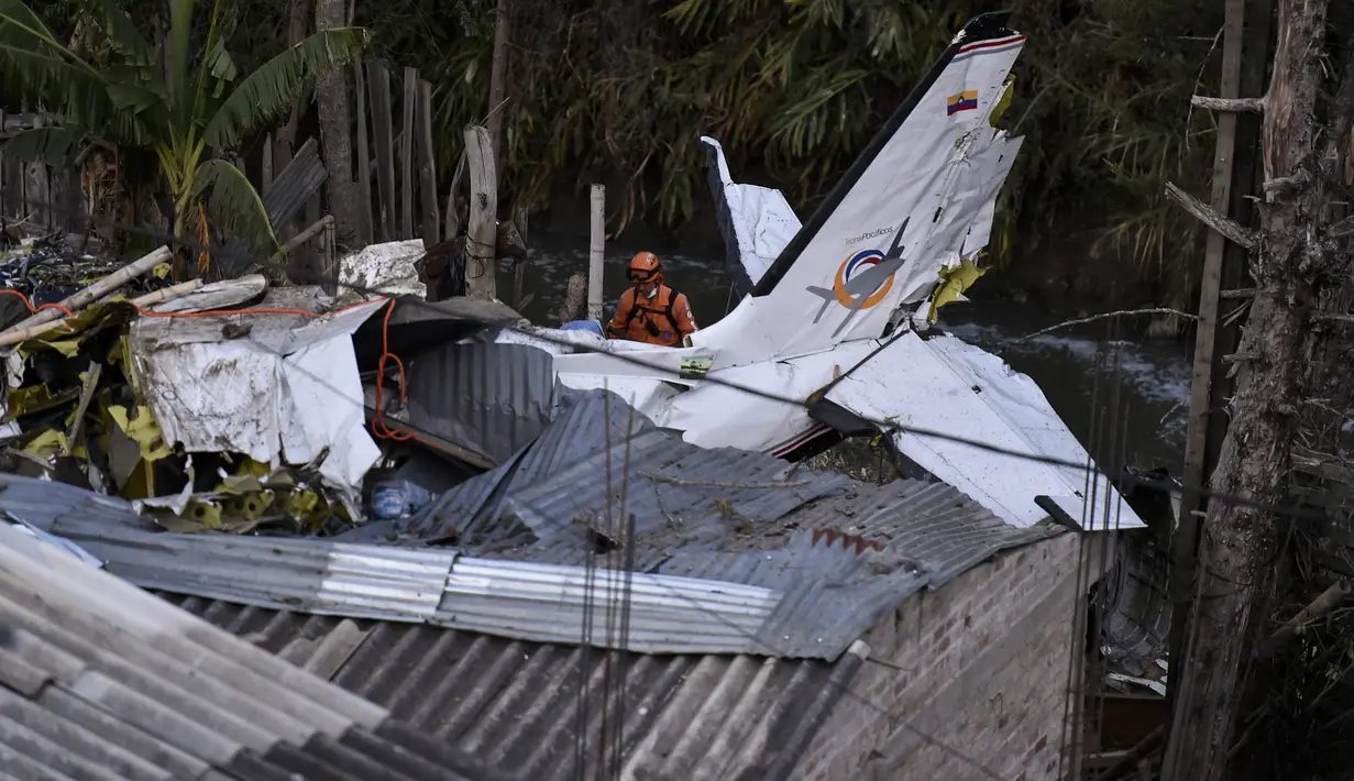 Tim penyelamat berada di lokasi jatuhnya sebuah pesawat kecil di tengah-tengah rumah penduduk di Popayan, Kolombia, Minggu (15/9/2019). Insiden tersebut mengakibatkan tujuh dari sembilan penumpang tewas. (Luis ROBAYO / AFP)