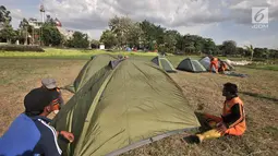 Petugas PPSU mendirikan tenda di Cipinang Melayu, Jakarta, Minggu (30/12). Pendirian puluhan tenda di RTH tersebut untuk kemah massal dalam menyambut malam Tahun Baru yang juga diisi dengan kegiatan doa bersama. (Merdeka.com/ Iqbal S. Nugroho)