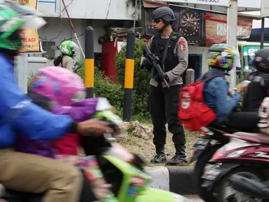 Polisi bersenjata laras panjang berjaga di jalur pantura Jalan Jenderal Ahmad Yani, Bypass, Kota Cirebon, Kamis (22/6). Pasukan bersenjata lengkap diterjunkan untuk mengantisipasi gangguan keamanan selama arus mudik Lebaran.  (Liputan6.com/Johan Tallo)