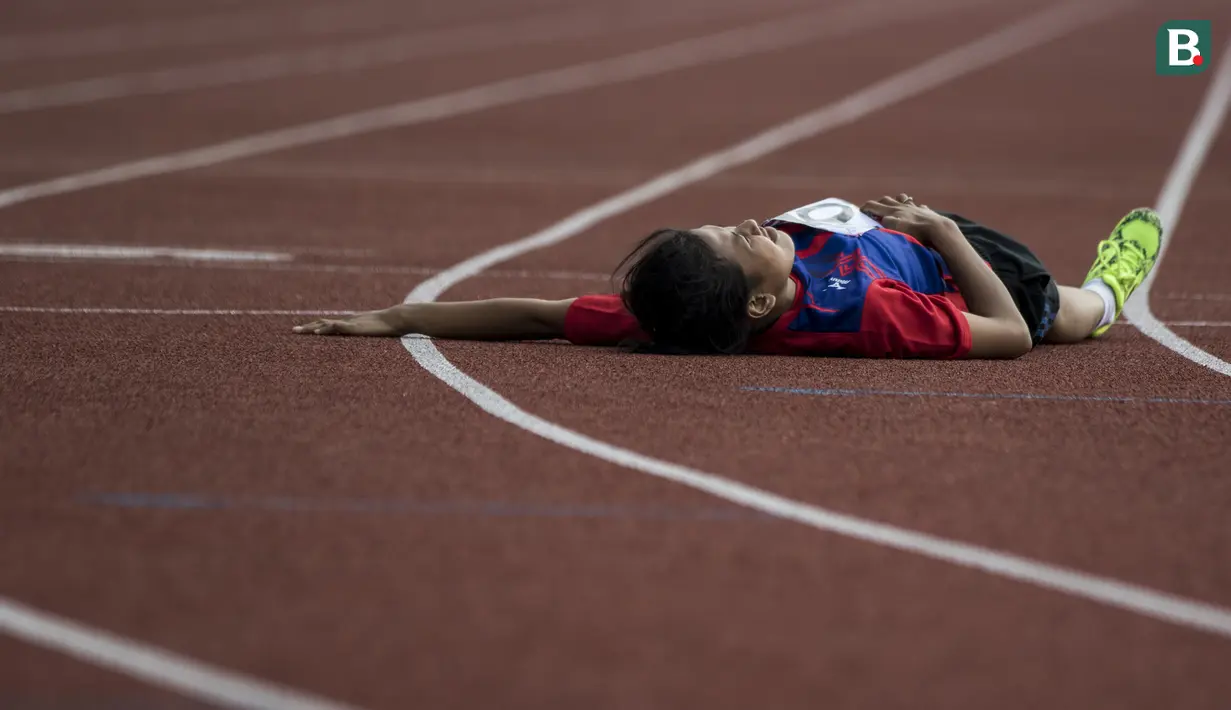 Pelari Indonesia, Fitria Siti Ayu, kelelahan hingga terjatuh pada Invitational Tournament Asian Para Games cabang atletik nomor 200 meter T 36/37/38 di Stadion Madya, Jakarta, Sabtu (30/6/2018). (Bola.com/Vitalis Yogi Trisna)