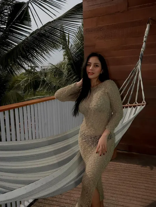 Rachel mengenakan sebuah dress lengan panjang menerawang bernuansa keemasan. Innernya Rachel mengenakan bikini hitam. [Foto: Instagram/rachelvennya]