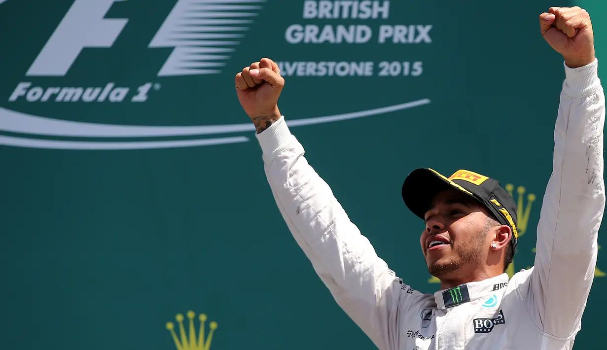 Pembalap Formula 1, Lewis Hamilton merayakan kemenangan usai berlaga di Grand Prix Formula 1 Silverstone di Inggris, (5/7/2015). Hamilton berhasil finish di urutan pertama dengan waktu 1 jam 31 menit 27,729 detik. (Reuters/Stringer)
