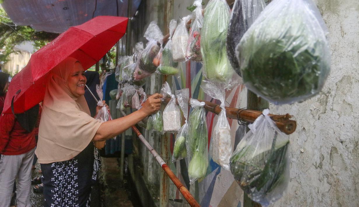 Warga memilih beberapa bahan masakan yang dibagikan secara cuma-cuma di permukiman RT 02/RW 04 kawasan Jati Padang, Jakarta, Jumat (6/3/2026). Selama Ramadan, terdapat sebuah kegiatan berbagi bantuan bahan makanan dan pakaian layak pakai yang rutin dilaksanakan dalam sembilan tahun terakhir. (merdeka.com/Arie Basuki)