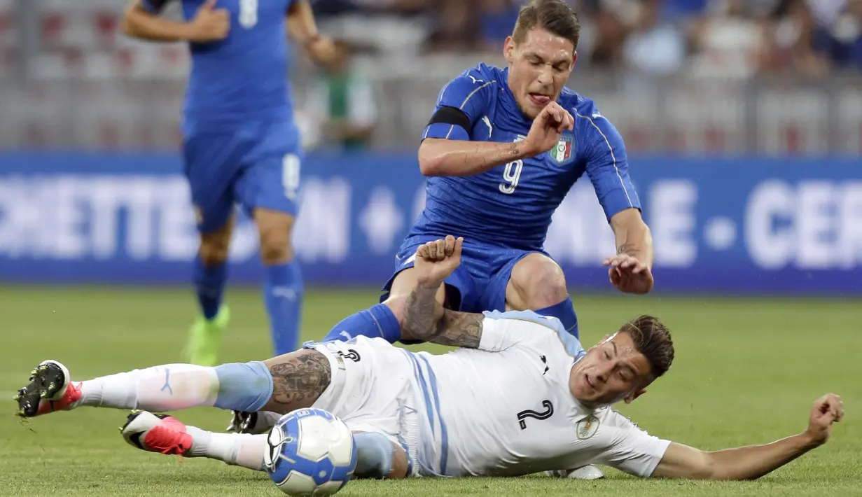 Pemain Italia, Andrea Belotti diadang pemain Uruguay,  Jose Gimenez (bawah)  pada laga Persahabatan di Nice Allianz Riviera stadium, Prancis, (7/6/2017). (AP/Claude Paris)