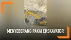 Warga India menyelamatkan diri dari bencana tanah longsor. Mereka menyeberangi sungai menggunakan ekskavator.