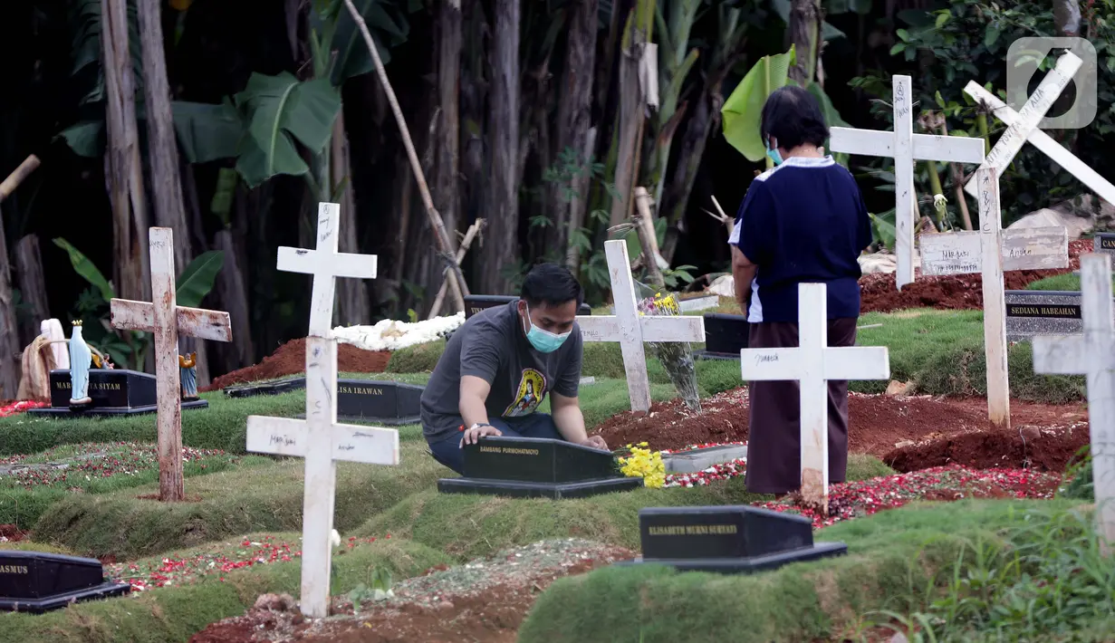 Warga berziarah di area pemakaman khusus dengan protokol COVID-19 di TPU Pondok Ranggon, Jakarta, Jumat (25/12/2020). Momen perayaan Natal 2020 dimanfaatkan sejumlah umat kristiani untuk berziarah mendoakan kerabat yang dimakamkan dengan protokol COVID-19. (Liputan6.com/Helmi Fithriansyah)