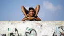 Yousef Al-Bahtini memperlihatkan keahlian akrobatiknya di pelabuhan Kota Gaza (20/9). Bocah Palestina ini siap memecahkan waktu tercepat rekor Guinness World Records dengan melakukan perjalanan 20 meter dalam kelenturan tubuh. (AFP Photo/Mohammed Abed)