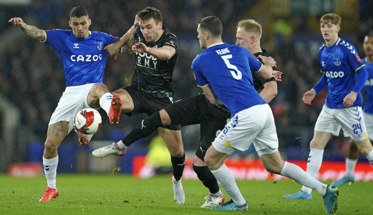 Pemain Everton Allan (kiri) berebut bola dengan pemain Boreham Wood, Josh Rees (kedua kiri) pada putaran kelima Piala FA Inggris di Goodison Park di Liverpool, Inggris, Jumat (4/3/2022). Kemenangan ini mengantar Everton lolos ke perempat final Piala FA. (AP Photo/Jon Super)
