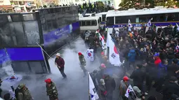 Demo pemakzulan Presiden Korea Selatan (Korsel), Park Geun-hye, berujung ricuh di Seoul, Jumat (10/3). Dua orang tewas dalam bentrokan antara demonstran dan polisi usai putusan pemakzulan Park Geun-hye dibacakan Mahkamah Konstitusi. (JUNG Yeon-Je/AFP)