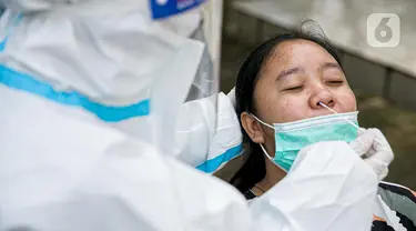 Petugas medis melakukan swab antigen terhadap pengungsi banjir di Universitas Borobudur, Cipinang Melayu, Jakarta, Minggu (21/2/2021). Pengungsi diwajibkan menjalani swab antigen untuk mencegah penyebaran COVID-19. (Liputan6.com/Faizal Fanani)