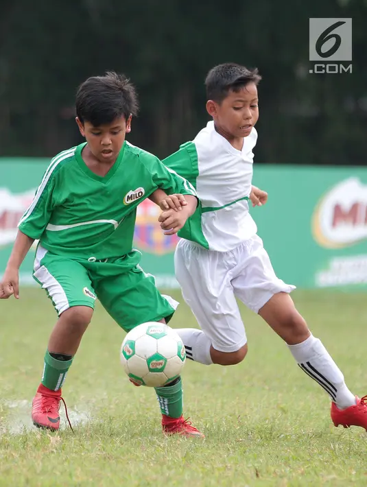 Dua pemain Tim Ponaryo dan tim Kurniawan berebut bola pada MILO Football Camp 2018 di ISCI, Ciputat, Sabtu. (12/5). Kedua tim bertanding untuk mendapat kesempatan berlatih ke Barça Academy Barcelona. (Liputan6.com/Pool/Rizky)