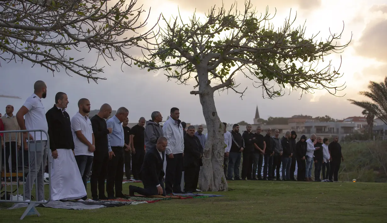 Umat muslim berkumpul untuk melaksanakan salat Idul Fitri yang menandai berakahirnya bulan suci Ramadan di sebuah taman di Jaffa, Israel, Minggu (24/5/2020). Jaffa merupakan kota campuran Yahudi-Arab. (AP Photo/Oded Balilty)