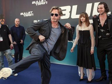 Brad Pitt bercanda dengan kameramen saat tiba pada pemutaran perdana film Bullet Train di Paris, Prancis, 18 Juli 2022. Brad Pitt menunjukkan penampilan energik saat dia menendang kakinya ke udara pada acara tersebut. (AP Photo/Lewis Joly)