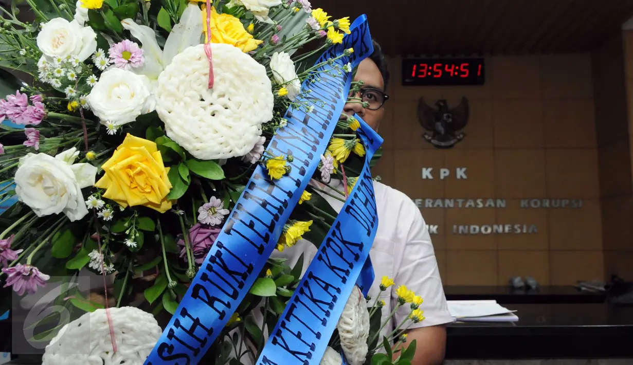 Seorang aktivis membawa karangan bunga yang dihiasi kerupuk saat berkunjung ke KPK, Jakarta, Rabu (16/12/2015). Mereka menolak RUU KPK dan berharap KPK tak melempem seperti kerupuk. (Liputan6.com/Helmi Afandi)