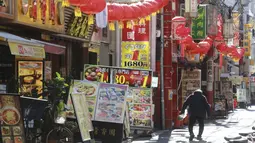 Seorang pria melintasi Chinatown yang dihiasi pernak-pernik Imlek di Yokohama, Prefektur Kanagawa, dekat Tokyo, Selasa (9/2/2021). Yokohama Chinatown adalah kawasan pecinan terbesar di Jepang, terletak di pusat kota Yokohama. (AP Photo/Koji Sasahara)