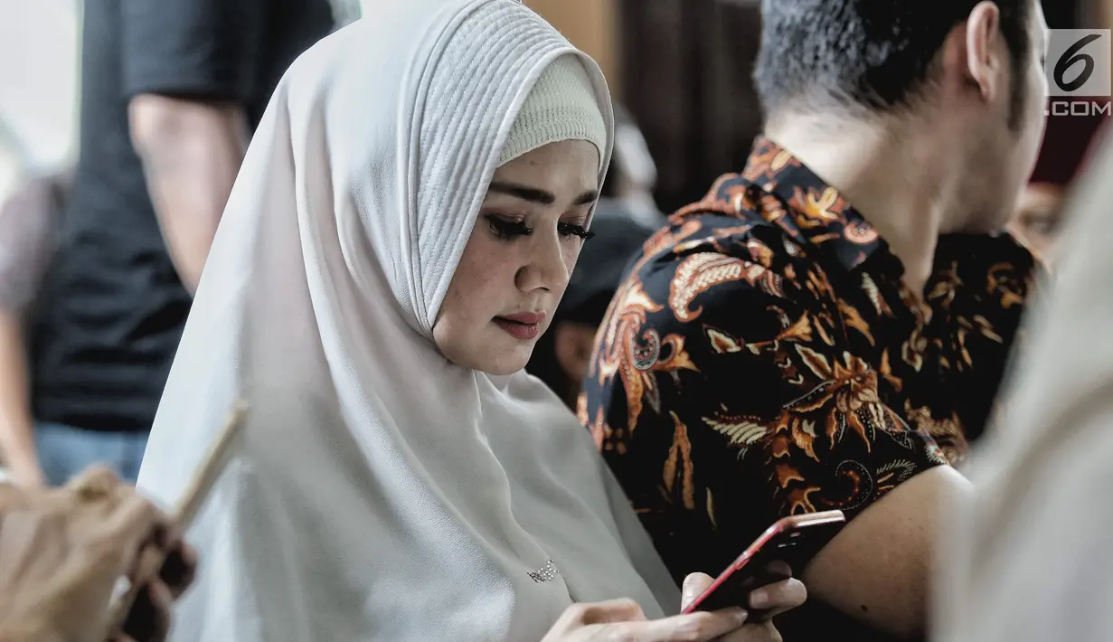 Penyanyi sekaligus istri musisi Ahmad Dhani, Mulan Jameela bermain handphone saat menghadiri sidang lanjutan kasus ujaran kebencian yang melibatkan sang suami di PN Jakarta Selatan, Senin (17/9). (Liputan6.com/Faizal Fanani)