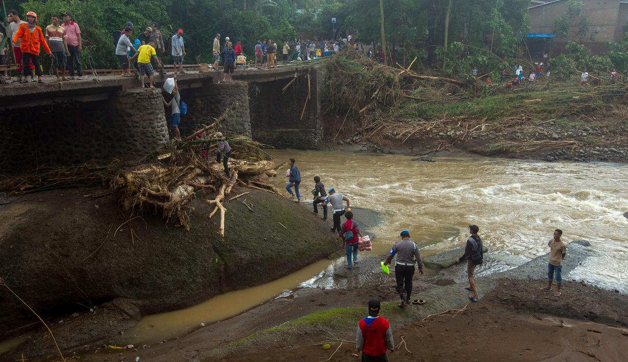 Tim SAR memperbaiki jembatan setelah tanah longsor melanda Gowa, Sulawesi Selatan, Jumat (25/1). Proses perbaikan terkendala cuaca buruk. (YUSUF WAHIL/AFP)