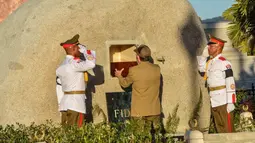 Presiden Kuba, Raul Castro meletakan kotak kayu berisi abu pemimpin Revolusi Kuba, Fidel Castro, ke dalam batu granit besar di pemakaman Santa Ifigenia, di Santiago, Kuba, (4/12). Fidel Castro meninggal pada usia 90 tahun. (REUTERS/ACN/Marcelino Vazquez)