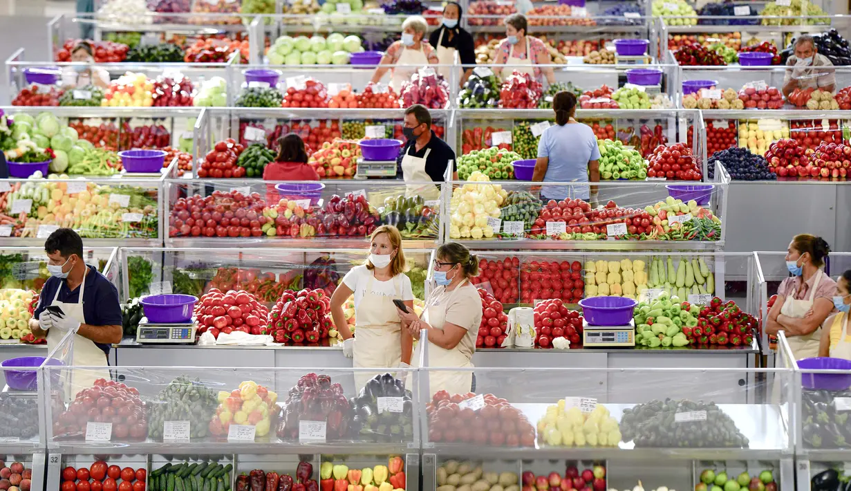 Penjual buah dan sayuran mengenakan masker untuk melawan penyebaran infeksi COVID-19 saat menunggu pelanggan di pasar Bucharest, Rumania, 11 Agustus 2020. Rumania dihadapkan pada peningkatan jumlah infeksi COVID-19 dan terkait kematian selama beberapa minggu terakhir. (AP Photo/Andreea Alexandru)