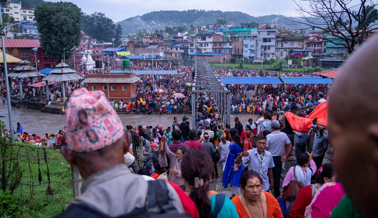 Anak-anak yang ayahnya masih hidup menunjukkan penghargaannya dengan memberikan hadiah dan permen, dan anak-anak yang ayahnya sudah meninggal memberikan penghormatan di Kuil Gokarneshwar. (AP Photo/Niranjan Shrestha)